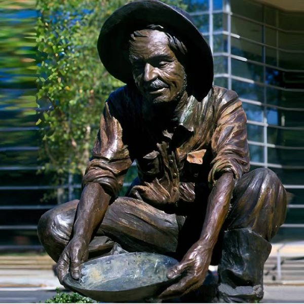 Bronze statue of an old man wearing a beret, rolled up sleeves, and short boots, squatting on the street pouring water with a basin - Image 3