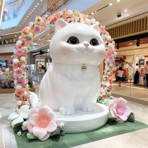 Large fiberglass cat sculpture in indoor shopping mall