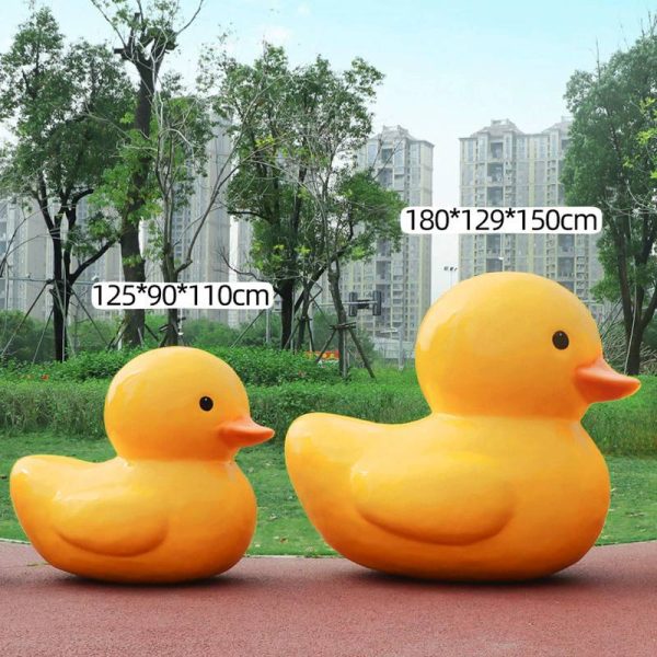 A fiberglass reinforced plastic sculpture of a small yellow duck in an outdoor park public area - Image 5