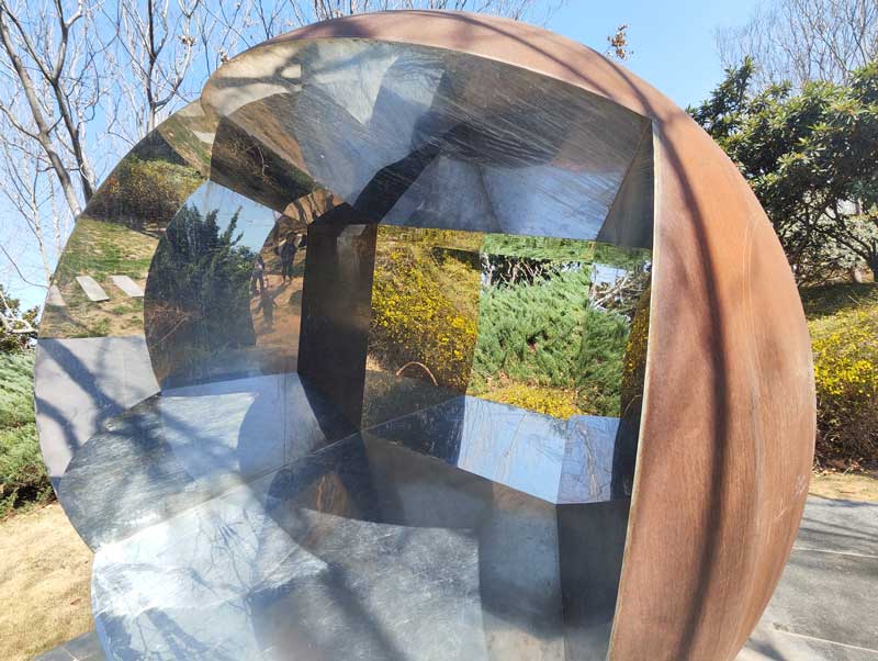 The spherical sculpture made of stainless steel and weathering steel contains the theme of "nature and infinity"