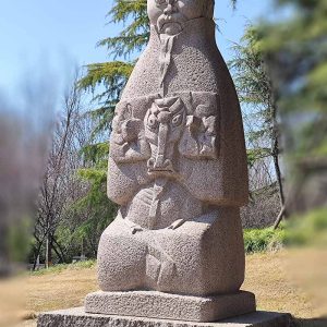 The stone sculpture of an old man holding an old sheep shows the harmonious coexistence of man and animals