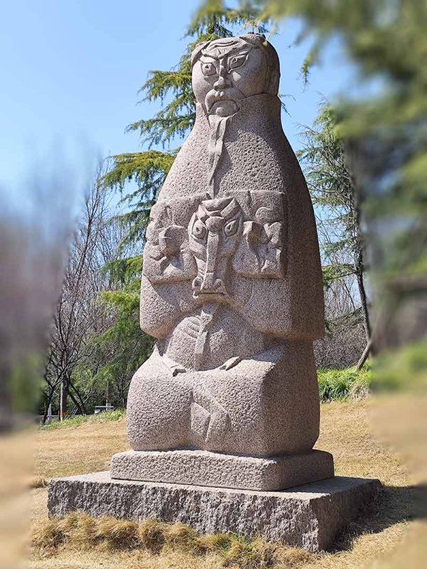 The stone sculpture of an old man holding an old sheep shows the harmonious coexistence of man and animals