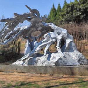Stainless steel sculpture of many people hiding under trees from the heavy snow