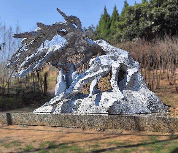 Stainless steel sculpture of many people hiding under trees from the heavy snow
